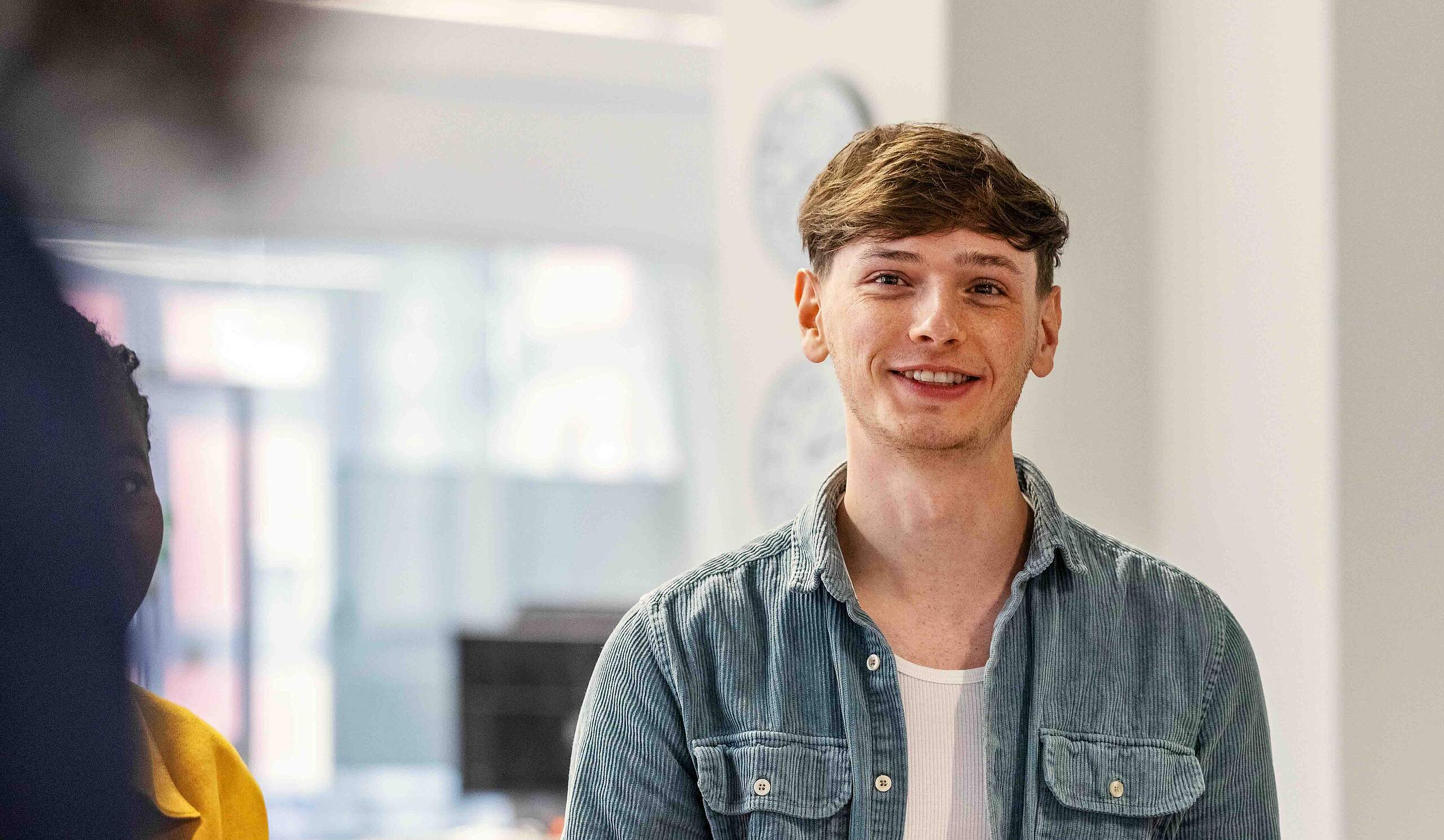 Zwei Männer sitzen nebeneinander und halten Dokumente in der Hand.