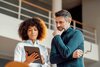bild Man and woman standing together looking at a tablet in an office.