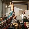 Woman standing in front of a group and presenting in a meeting room.